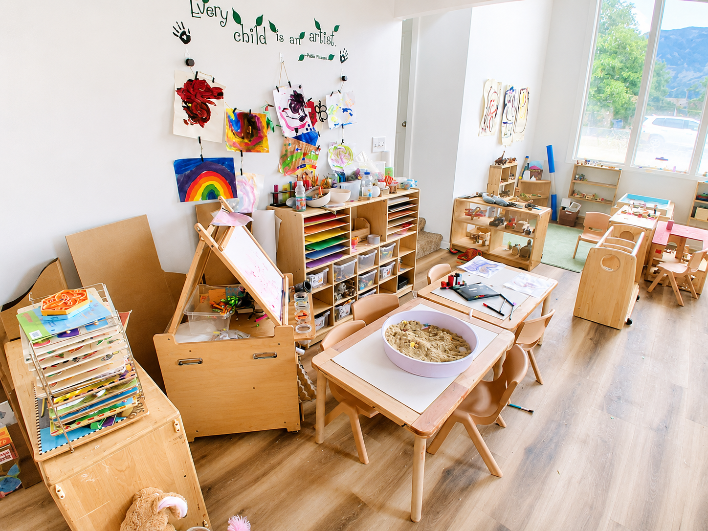 Bright art room at Mom Pod Orem with colorful children's artwork